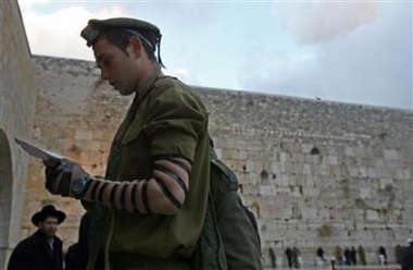 An Israeli soldier prays at the Western Wall, Judaism's holiest prayer site, in Jerusalem's Old City January 8, 2006. 