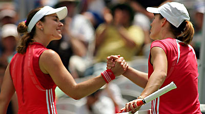 Switzerland's Martina Hingis (L) and Belgium's Justine Henin-Hardenne shake hands after their first-round match at the Sydney International Tennis tournament January 9, 2006. Henin-Hardenne won 6-3 6-3. 