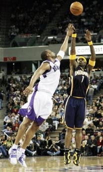 Stephen Jackson (1), pulls up for a three point shot over Sacramento Kings' Kenny Thomas, left, at the end of the third quarter of their NBA basketball game in Sacramento, Calif., Sunday, Jan. 8, 2006. 