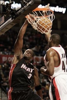 Miami Heat guard Dwyane Wade, left, stuffs the ball over Portland Trail Blazers center Theo Ratliff during second half NBA basketball action in Portland, Ore., Sunday, Jan. 8, 2006.