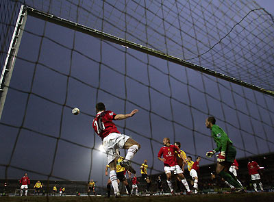 Manchester United's Phil Bardsley (L) heads the ball off the goal line as Burton Albion attack during their FA Cup third round soccer match in Burton-on-Trent, central England January 8, 2006. [Reuters]