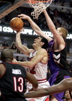 Chicago Bulls Kirk Hinrich, center, is fouled on his way to the basket by Toronto Raptors' Matt Bonner, right, as the Raptors' Mike James (13) looks on during the fourth quarter of an NBA basketball game Monday, Jan. 9, 2006 in Chicago. 