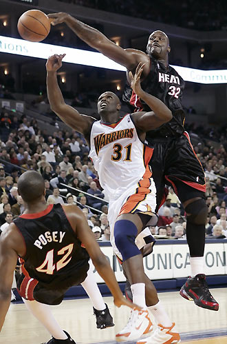 Miami Heat Shaquille O'Neal (R) blocks a shot by Golden State Warriors Adonal Foyle (C) as Heat's James Posey falls to the floor in the first half of an NBA game in Oakland, California January 11, 2006. [Reuters]