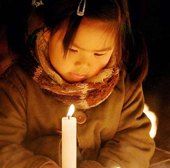 A girl lights a candle to offer a prayer for victims killed by the 1995 Kobe earthquake on the eve of the 11th anniversary at a park in Itami, near the western Japanese port city of Kobe, January 16, 2006. The earthquake which hit western Japan killed more than 6,400 people in 1995. 