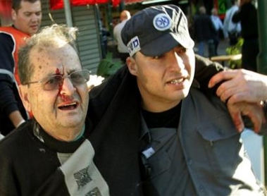 An Israel police officer helps a wounded man at the site of a suicide bombing in Tel Aviv,Israel, Thursday Jan. 19, 2006.