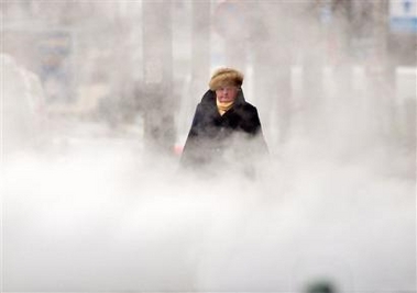A woman is engulfed by steam from an underground ventilation system while walking in a Bucharest, Romania, street on a very cold morning Monday Jan. 23, 2006.