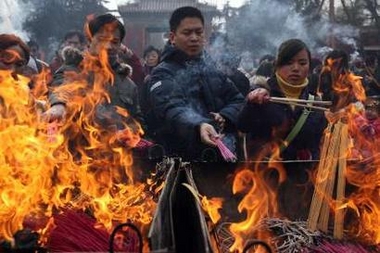 Chinese worshippers pray and offer incense at a temple during the second day of the Lunar New Year festival in Beijing January 30, 2006.