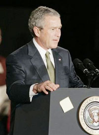 A 3M Post-it note that President Bush placed on the front of the podium moments before falls as he prepares to speak at the Maplewood, Minn., company, known for its yellow Post-its, Thursday, Feb. 2, 2006 . Bush called for promoting research and technnology in a competitive world. (AP 