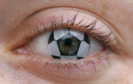 German optician Stephanie Berndt wears a soccer ball contact lens in Munich February 6, 2006. A set of 'Magic Lens' contact lenses with images of one soccer ball and a German flag cost 45 euros (54 U.S. Dollars). [Reuters]