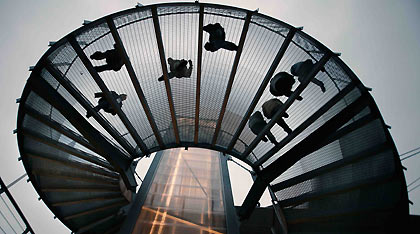 Athlets returning to their village in the Olympic Park descend a circular staircase in Turin, Italy February 8, 2006. The Torino 2006 Winter Olympic Games get underway February 10. 