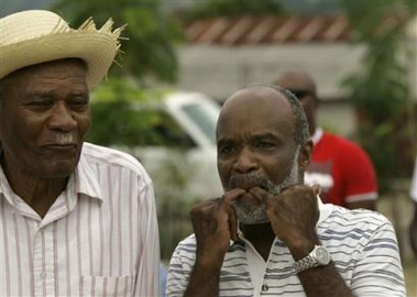 Haitian presidential candidate Rene Preval, right, whistles at someone at his hometown in Marmelade, Haiti on Thursday, Feb. 9, 2006. Preval is awaiting official election results although results compiled from his own party give him a strong lead in partial returns.(AP