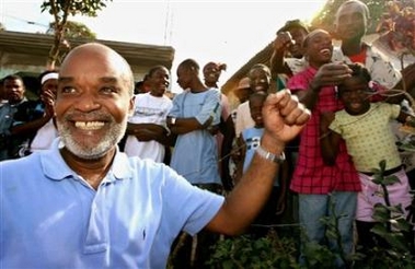Haitian presidential candidate Rene Preval waves to supporters after casting his ballot in the hamlet of Marmelade, near Gonaives, February 7, 2006. 