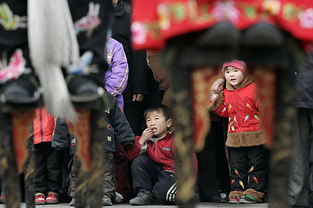 Chinese children watch performers on stilts during activities to mark Lantern Festival in Beijing February 12, 2006. Lantern Festival marks the last day of the 15-day long Spring Festival, the most important festival of the year in China. 