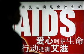 A person waits for a train in front of an AIDS awareness poster in a Beijing subway station last month. 