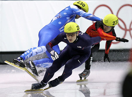 J.P. Kepka (252) from the U.S. skates as Yuri Confortola (230) from Italy crashes with Takahiro Fujimoto (235) from Japan in the men's 5000 metres short track speed skating relay semi-finals at the Torino 2006 Winter Olympic Games in Turin, Italy, February 15, 2006. [Reuters]