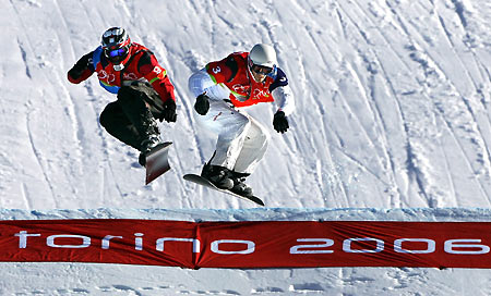 Seth Wescott of the U.S (R) jumps ahead of Slovekia's Radoslav Zidek (L) during the final of the snowboard cross competition at the Torino 2006 Winter Olympic Games in Bardonecchia, Italy, February 16, 2006. [Reuters]