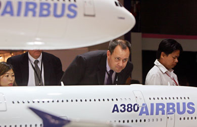 A trade visitor looks at a model of the Airbus A380 aircraft at the Asian Aerospace 2006 airshow in Singapore February 21, 2006. The Asian Aerospace 2006 will be held for six days starting February 21, with the Airbus A380, the biggest passenger aircraft to date, as one of the show's highlights.