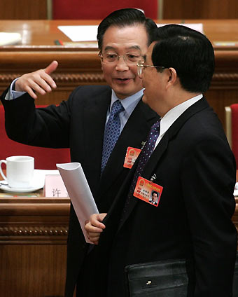Chinese president Hu Jintao (R) talks with Premier Wen Jiabao after a session of the National People's Congress at the Great Hall of the People in China's capital Beijing March 11, 2006. China's National People's Congress is in the middle of its annual session, with economic reforms and revival of the countryside among the top issues to be discussed. [Reuters]