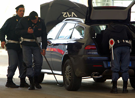 An italian policeman inspects a bus as it enters the Palavela venue for the Torino 2006 Winter Olympic Games in Turin. [Reuters]