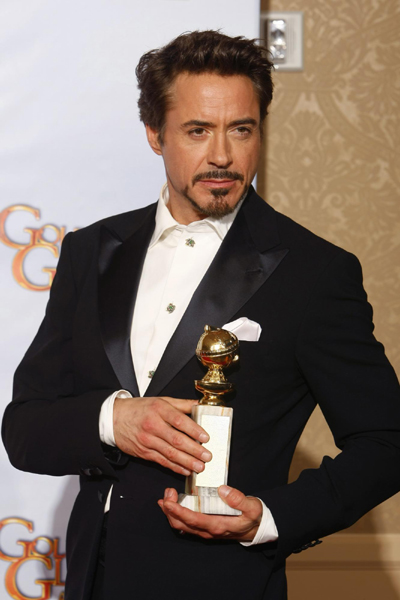 Robert Downey Jr. poses with his award for Best Performance by an Actor in 