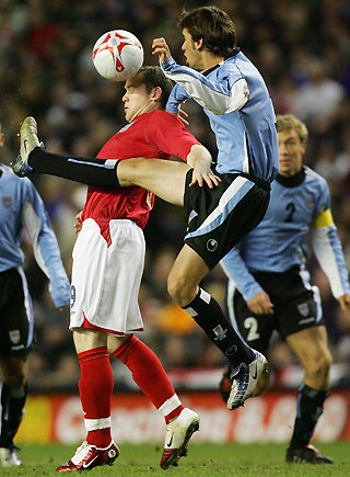England's Wayne Rooney (L) battles for the ball with Uruguay's Diego Godin (R) during their international friendly soccer match at Anfield in Liverpool, northern England March 1, 2006. [Reuters]