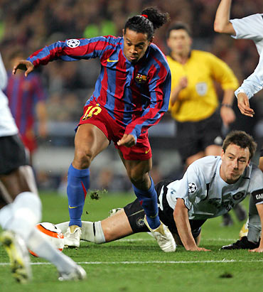 Barcelona's Ronaldinho (L) of Brazil dribbles past Chelsea's John Terry (bottom R), 