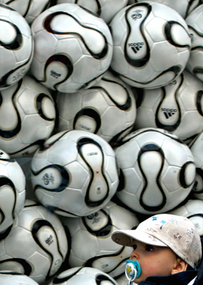 A young Croatian boy is carried past a shop-window filled with World Cup soccer balls in the Croatian capital of Zagreb June 5, 2006. [Reuters]