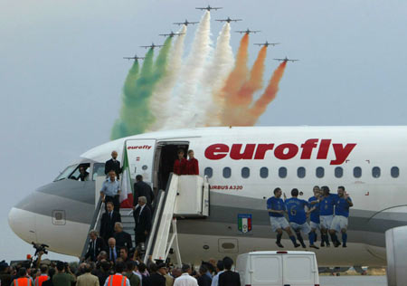 Italian air force planes trail smoke in the colours of the country's flag as Italy's national soccer team arrives after the World Cup 2006 at the Pratica di Mare air force base near Rome July 10, 2006. 