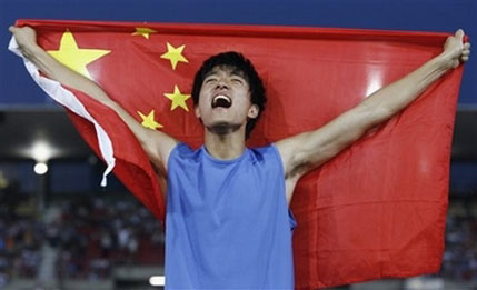 China's Liu Xiang celebrates on the podium after the men's 110 meter hurdles race at the Athletissima athletics meeting in Lausanne, Switzerland, Tuesday, July 11, 2006. Liu Xiang won the race and set a new world record with a time of 12.88 seconds. (AP Photo