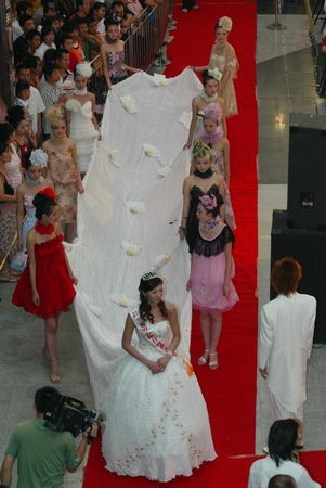 A 9.9-meter-long wedding dress is shown during the International Wedding Dress which kicked off in Dalian, northeast China's Liaoning Province Saturday. [New Business]