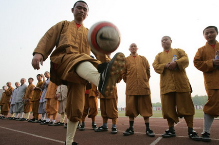 A monk plays soccer at a school in Southwest China's Chongqing, April 20, 2006. Some 24 monks organized the first soccer team of monks in Chongqing April 19, 2006. [Zhao Rui/Chongqing Times] 