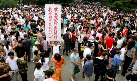 Shi Wenmao, 23, holds a banner during a mass match-making event in Changchun, Northeast China's Jilin Province, July 30, 2006. The Chinese characters on the banner read 