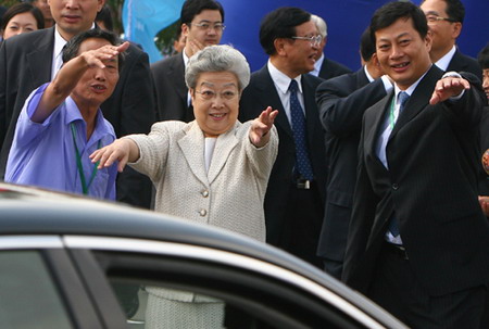 China's Vice Premier Wu Yi (C) invites workers to have a photo taken together during her visit to an investment and trade expo in Jilin Province, September 2, 2006. [Zhao Bin/New Culture Newspaper]