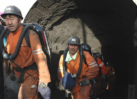 Coal miners walk out of a tunnel after a rescue mission to save miners trapped after a blast in Otog Banner in Ordos, North China's Inner Mongolia Autonomous Region, May 13, 2006. The blast killed 18, and 13 survived. [Inner Mongolia Morning News]