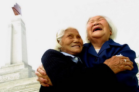 Xie Yuanzhen (R) and Du Wenkai pose for a picture in front of the August 1 Uprising Monument in Nanchang, East China's Jiangxi Province, May 29, 2006. Xie met Du for the first time when they were both soldiers in the Red Army 70 years ago. [Li Wei/Jiang'nan Metropolitan News]