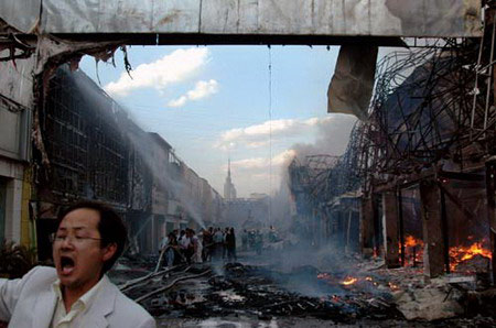 A man reacts as firemen try to put out a fire at a construction material market in Kunming, Southwest China's Yunnan Province, April 22, 2006. [Zhao Yongfeng/Spring City Evening]