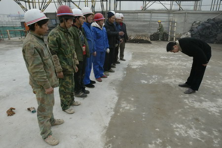 A Shuqin Labor Co. Ltd. (Xi'an Branch) manager bows before a row of migrant workers in Xi'an, North China's Shannxi Province, January 12, 2006. One company supervisor took consolation money from the migrant workers. Later, the manager apologized to the migrant workers and returned the money to them. The supervisor was fired as punishment. [Zhao Xiongtao/ Huashang News]