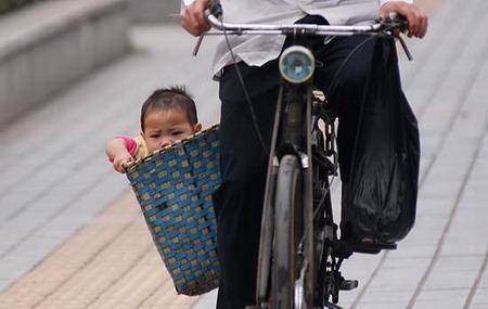 A cyclist carries a boy in Changsha, Central China's Hunan Province, October 10, 2006.[Tian Chao/Sanxiang City Express]