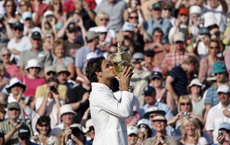 Switzerland's Roger Federer kisses the trophy after winning his men's final match against Spain's Rafael Nadal at the Wimbledon tennis championships in London, July 8, 2007. 