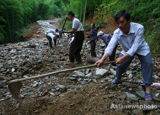 Villagers rebuild sole road after flood