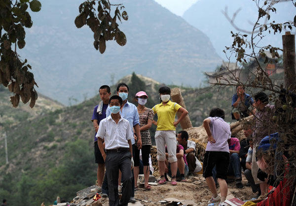 Landslide survivors waiting for families on ruins