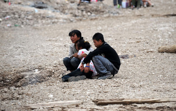 Landslide survivors waiting for families on ruins