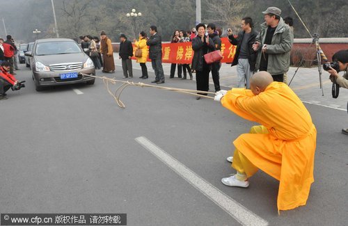 Buddhist nun shows off her strength pulling cars