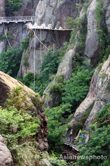 Chinese spider men work on cliffs