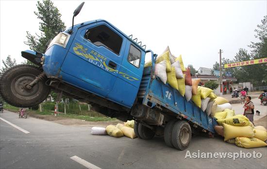 Overloaded farm vehicle does a wheelie