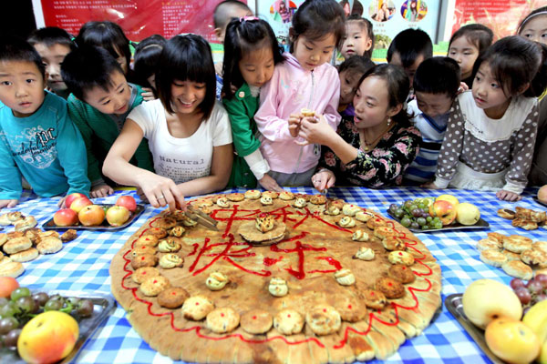 Children learn to make festival delicacy