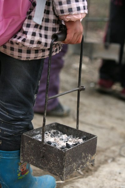 Burning charcoal to warm school run