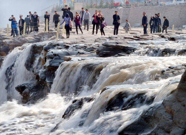 Tourists view Hukou Waterfall on Yellow River