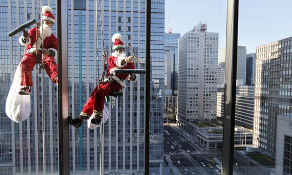 Window cleaners dress as Santa in Tokyo