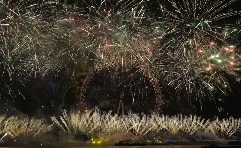 Fireworks explode around the London Eye wheel